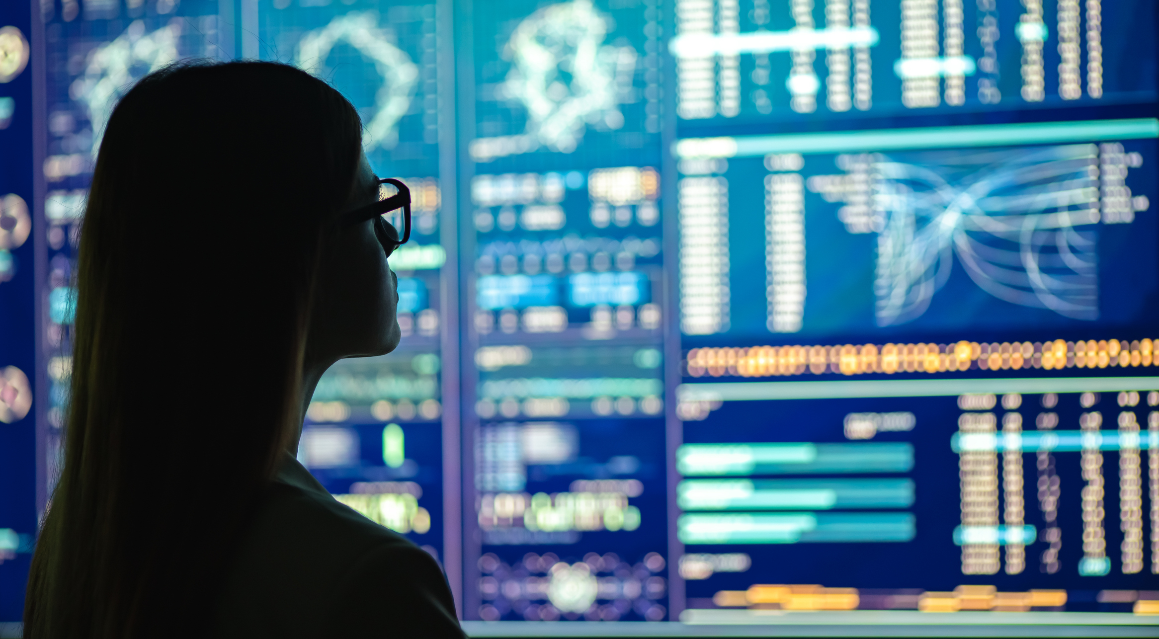ALT Text a Woman looking at digital information on multiple screens