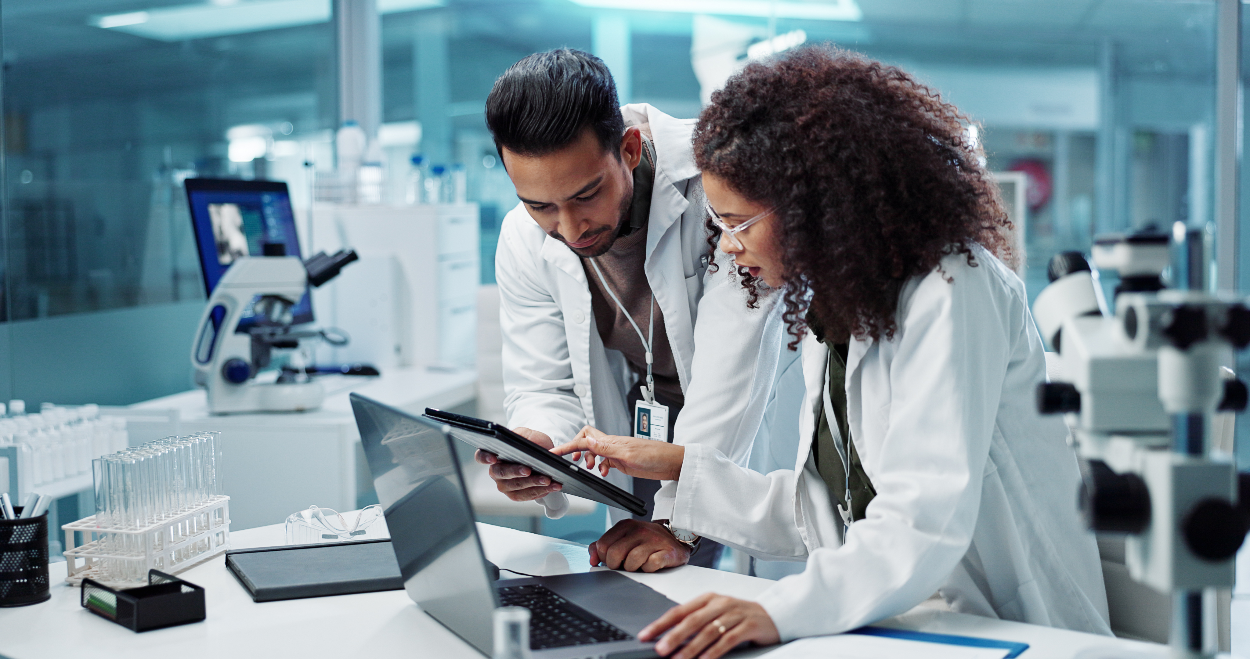 ALT Text: A man and woman talking and discussing in a medical lab 