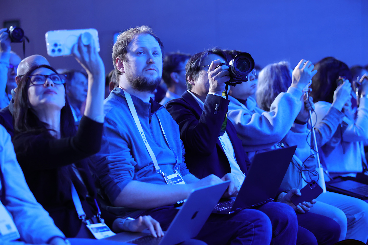 ALT Text: A group of people taking picture of the CES keynotes 