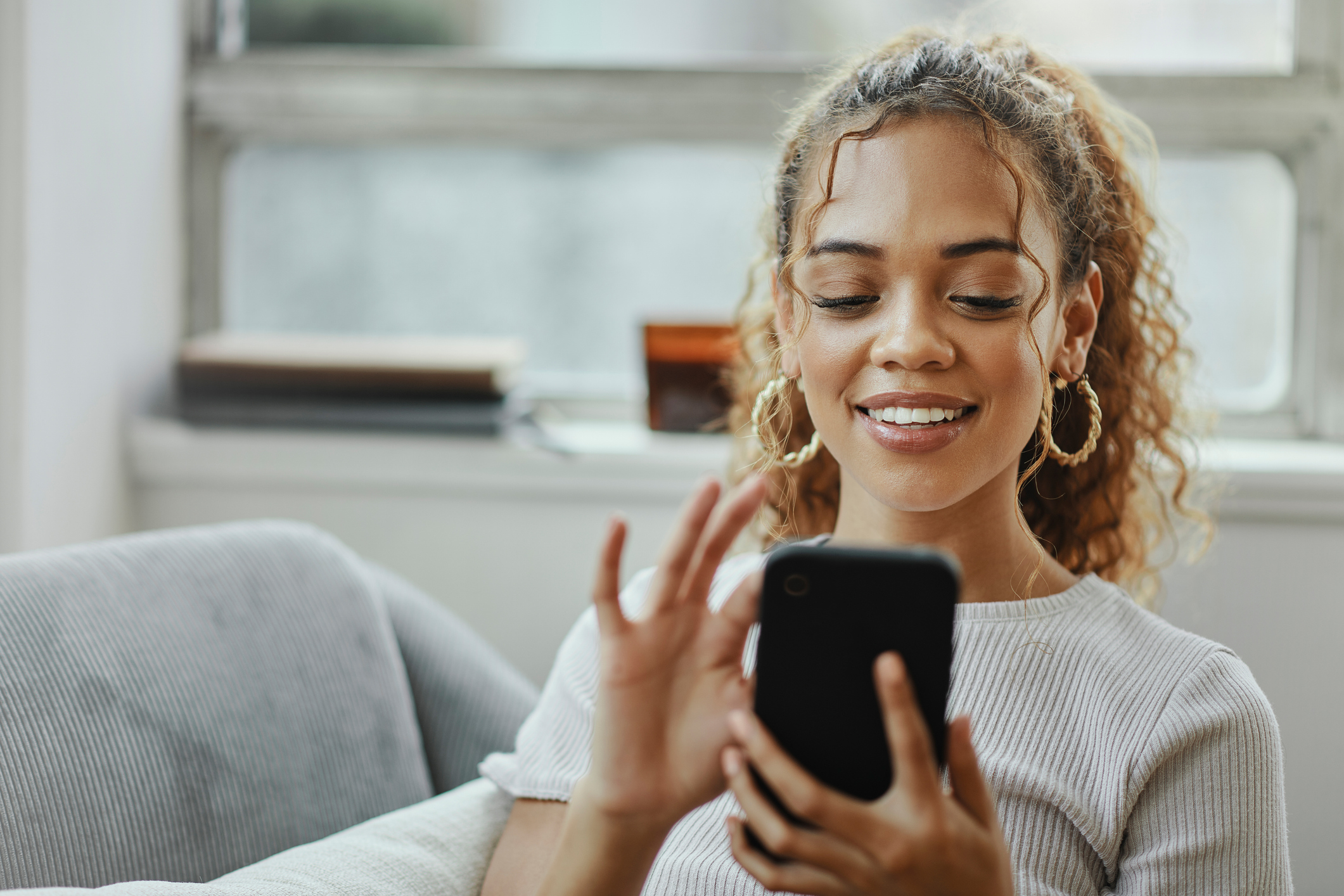 ALT Text: a girl sitting watching an ad on her phone